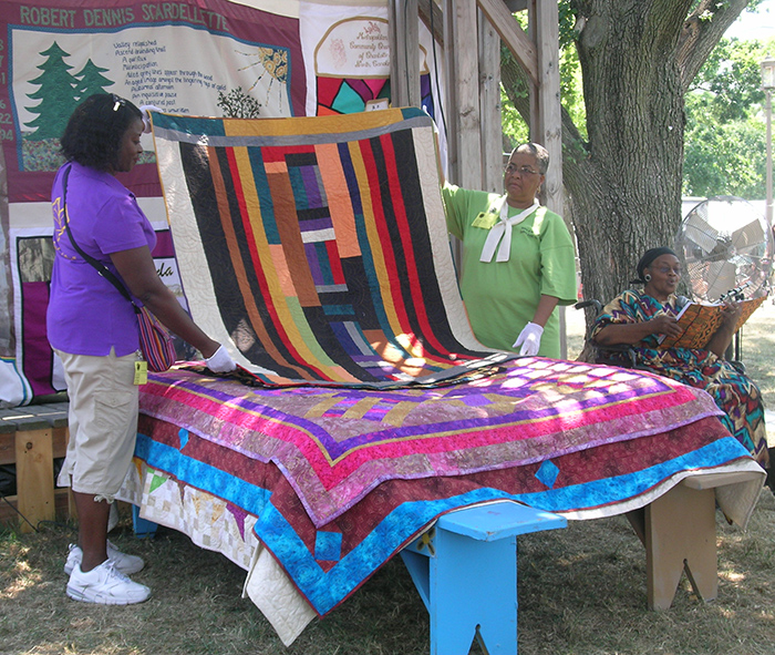 Sisters of the Cloth, affiliated with Indiana University's Traditional Arts Indiana program, demonstrate Bed Turning at the Commons.