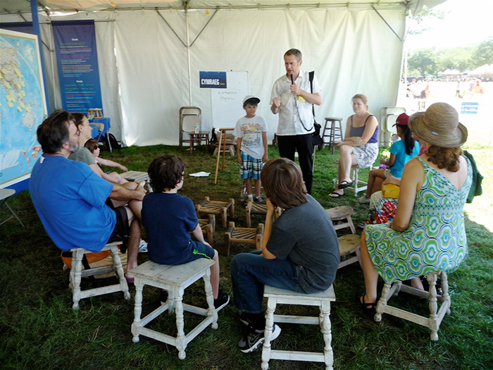 Studious visitors at the One World, Many Voices program's Family Activities area spent forty-five minutes one afternoon last week composing poetry with participant Ifor ap Glyn from Caernarfon, Wales. Photo by Betty J. Belanus