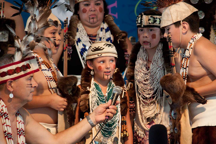Siletz cultural expert and language educator Bud Lane holds the microphone as young members of the Confederated Tribes of Siletz Indians sing a traditional chant at the 2013 Folklife Festival. Photo by Katherine Moore, Ralph Rinzler Folklife Archives