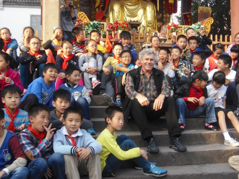 Folklorist and curator Jim Deutsch enjoys a martial arts performance along with schoolchildren at a Buddhist temple in Jinhua, Zhejiang Province.