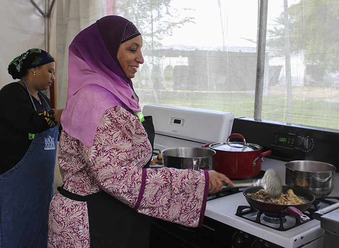 Fatma Ali Busaidy (in purple) prepares a traditional Swahili dish in the Flavors of Kenya foodways tent. Photo by Akea Brown, Ralph Rinzler Folklife Archives and Collections, Smithsonian Institution
