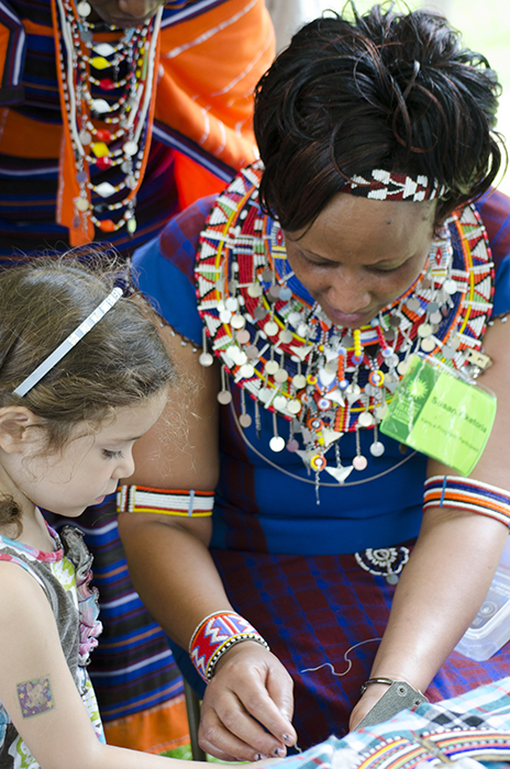 Susan Nketoria shows off bead work to a young visitor.