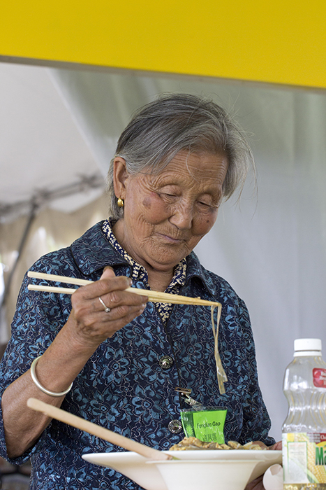 Master paper cutter Gao Fenglian enjoys some leftovers from the Five Spice Kitchen foodways demonstrations.