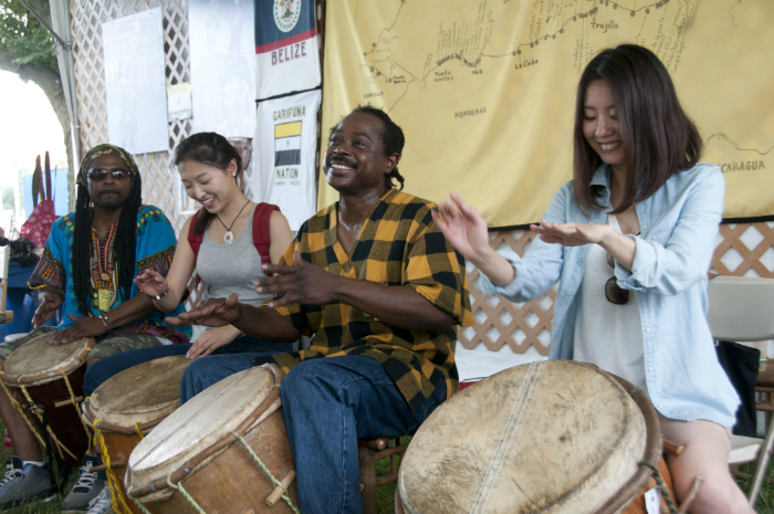 Musicians Dayton and Kelsie Bernardez play drums with visitors at the 2013 Smithsonian Folklife Festival.