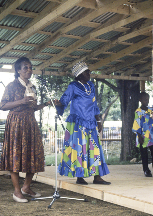 Olive Lewin moderates a session featuring a Kumina band from Jamaica, with Imogene "Queenie" Kennedy (right) at the 1989 Smithsonian Folklife Festival program The Caribbean: Cultural Encounters in the New World. Ralph Rinzler Folklife Archives and Collections, Smithsonian Institution