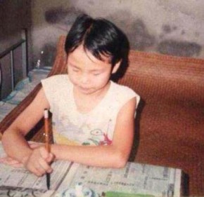 Author Qiaoyun Zhao practicing calligraphy at home in China when she was a child. Photo courtesy of Qiaoyun Zhao