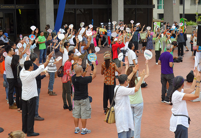 A group learns the <em>FandangObon</em> dance with fans. Photo by Deborah Wong