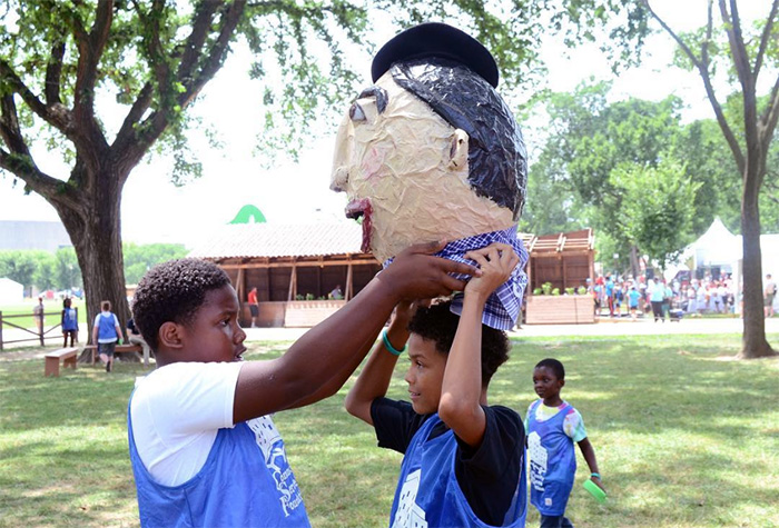 Young visitors try on "Charlie" the big head after a game of sponge tag at the Txiki-Txoko. Photo by Ravon Ruffin, Ralph Rinzler Folklife Archives