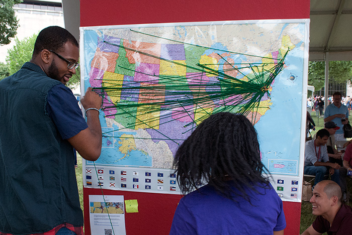 <em>On the Move</em> volunteers help visitors map out three points on a map: birth place, home, and current residence. Photo by J.B. Weilepp, Ralph Rinzler Folklife Archives