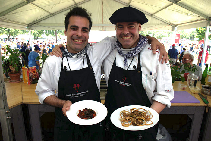 Chefs Igor Cantabrana (left) and Igor Ozamiz Goiriena (right) show off their completed dishes, porcini mushrooms and snails, in the Ostatua Kitchen. Photo by Walter Larrimore, Ralph Rinzler Folklife Archives